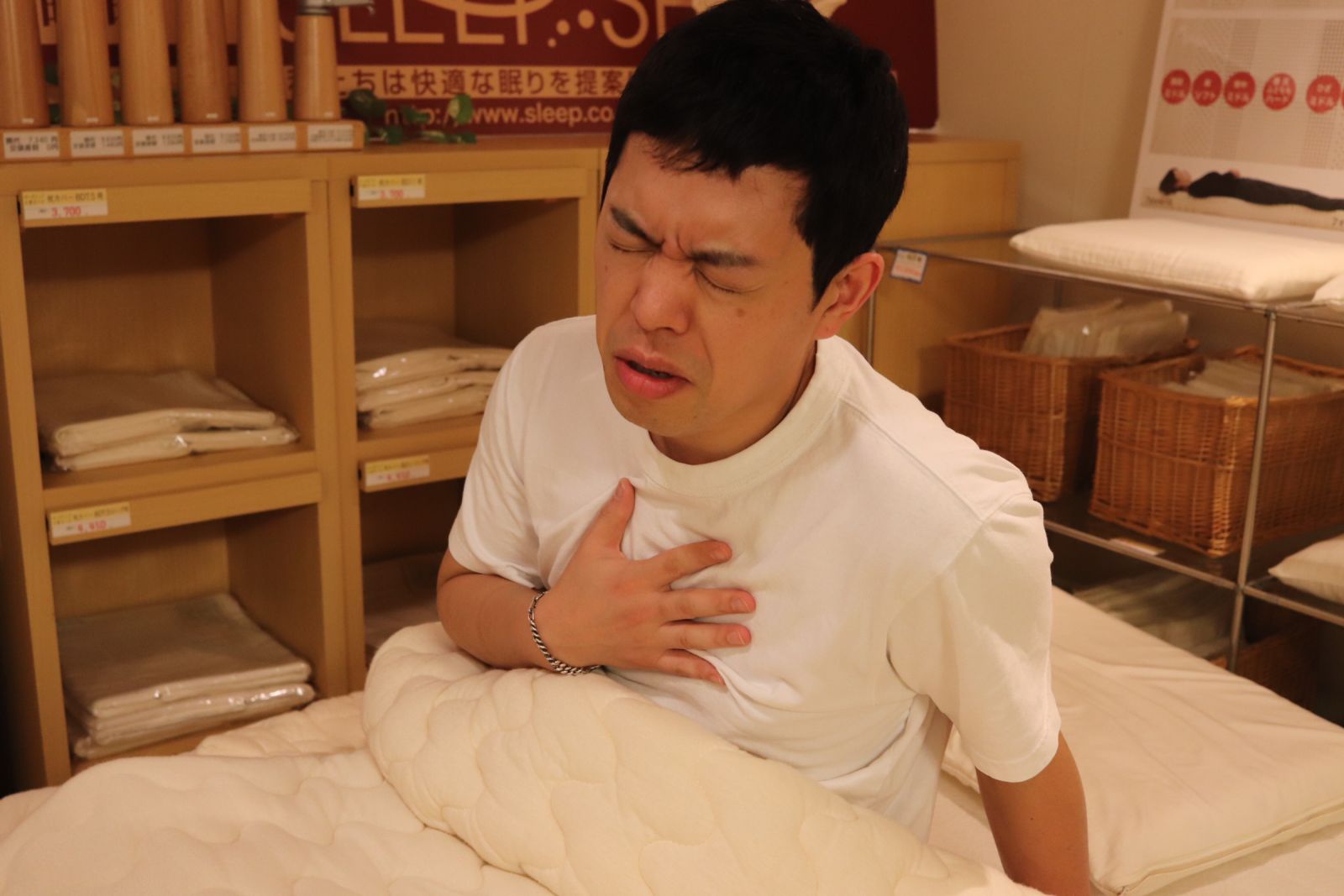 ベッドから起き上がり胸を苦しそうにして座っている写真